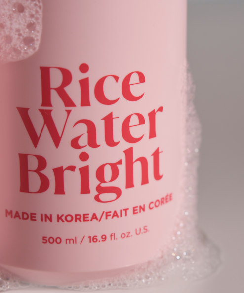 Rice Water Bright Essential Shampoo closeup covered in bubbles.