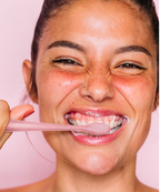 A model brushing her teeth with the Euthymol Whitening Toothbrush.