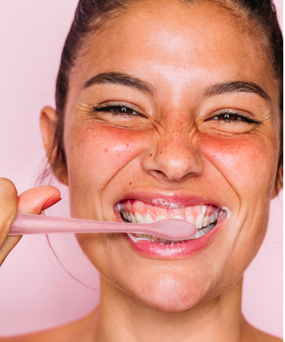 A model brushing her teeth with the Euthymol Whitening Toothbrush.