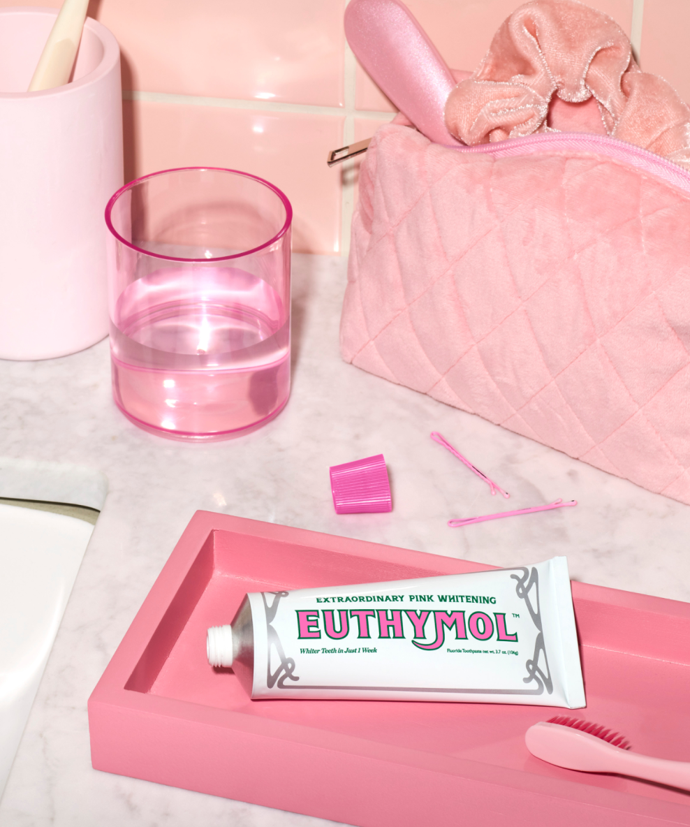 An image showing a bathroom counter with the Euthymol Whitening Toothpaste on a pink tray.