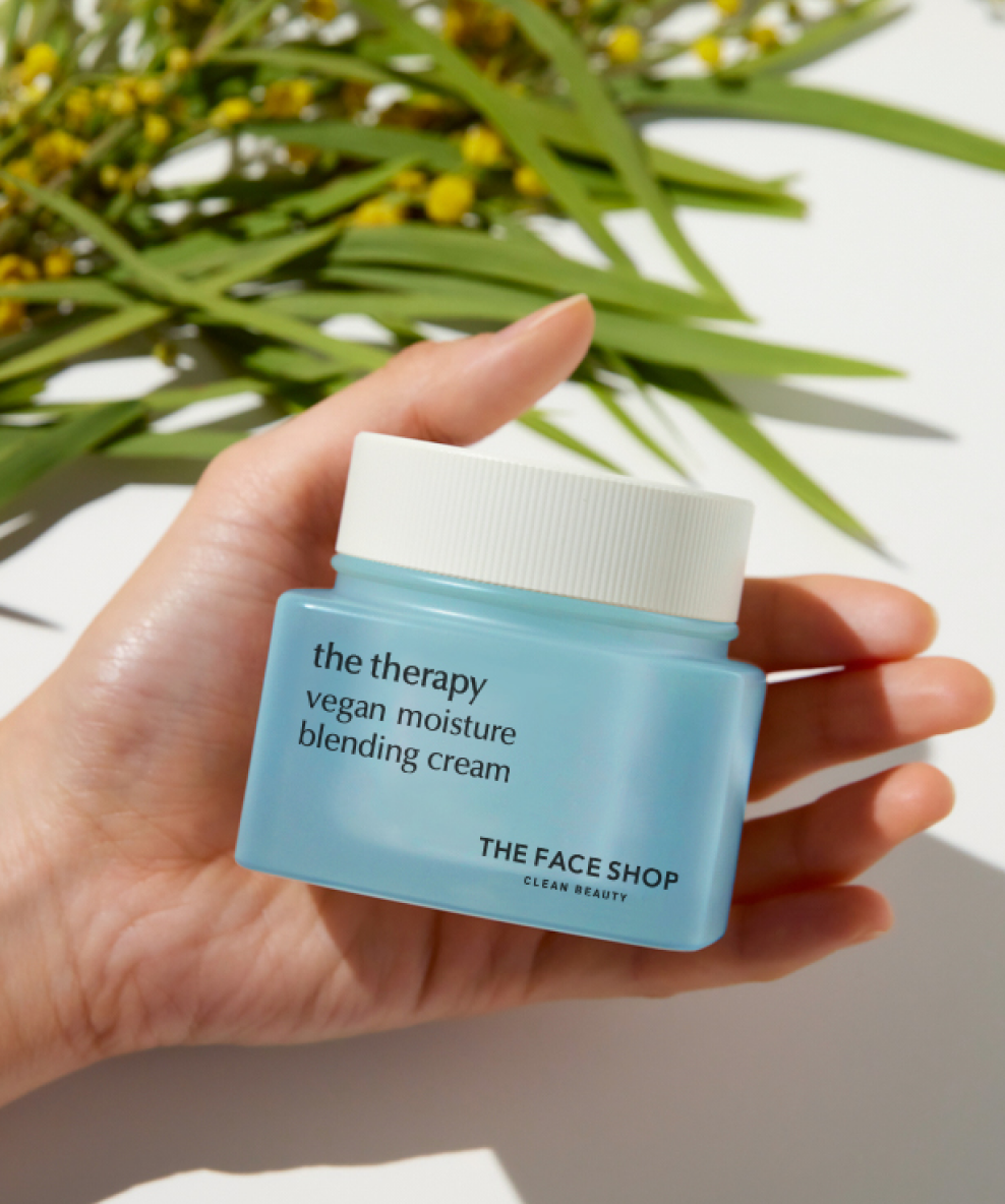 An mage showing The Therapy Vegan Moisture Blending Cream jar in a woman's hand.