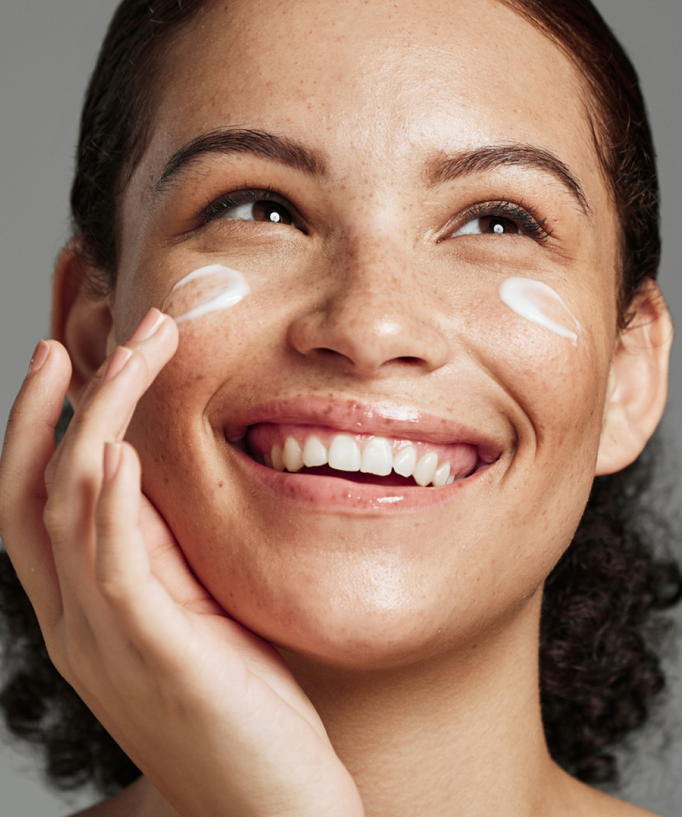 An image of a model applying Tea Tree Pore Cream to her face.